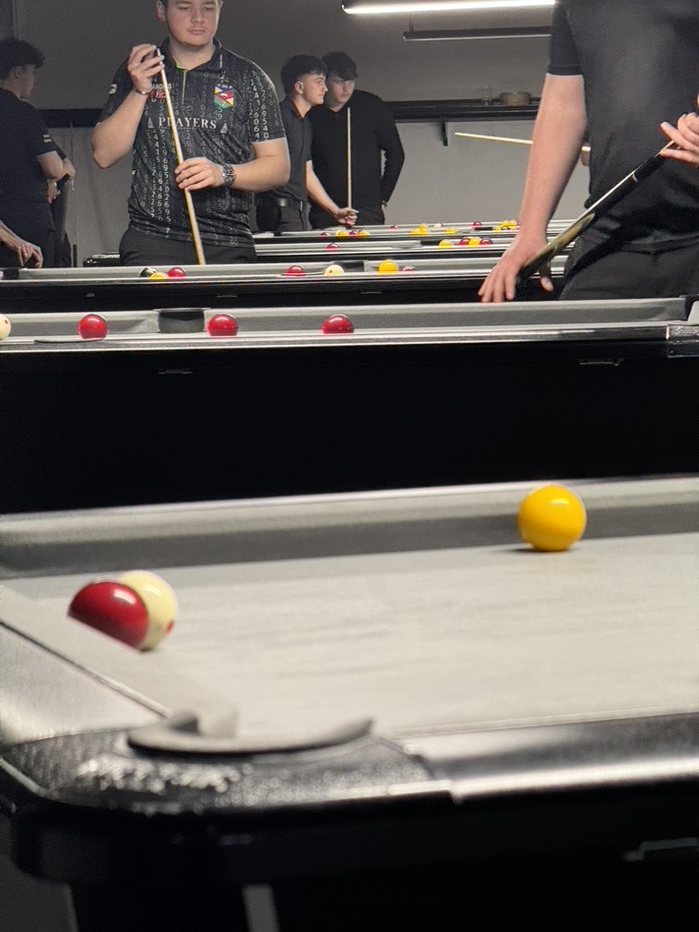 Close-up of red and yellow balls near a corner pocket during a match.